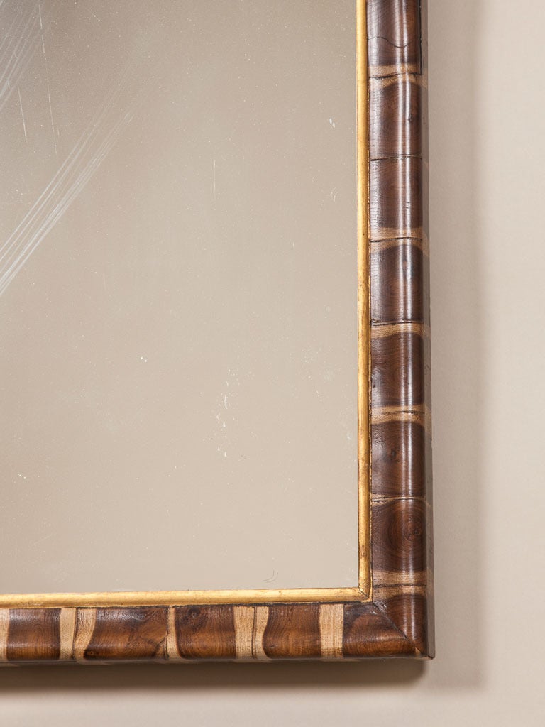 A late 19th century pier mirror in the Queen Anne taste with a shaped top and a narrow oyster veneered frame.