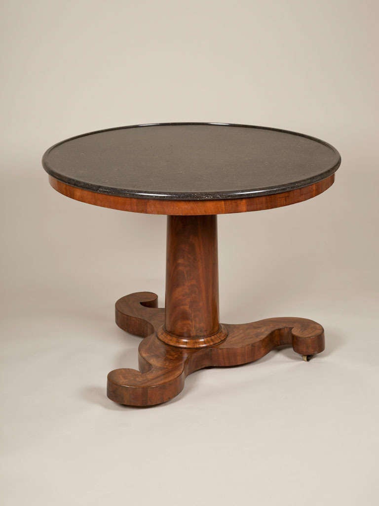 An early 19th century mahogany gueridon with a propeller base and fossil marble top. Circa 1820.