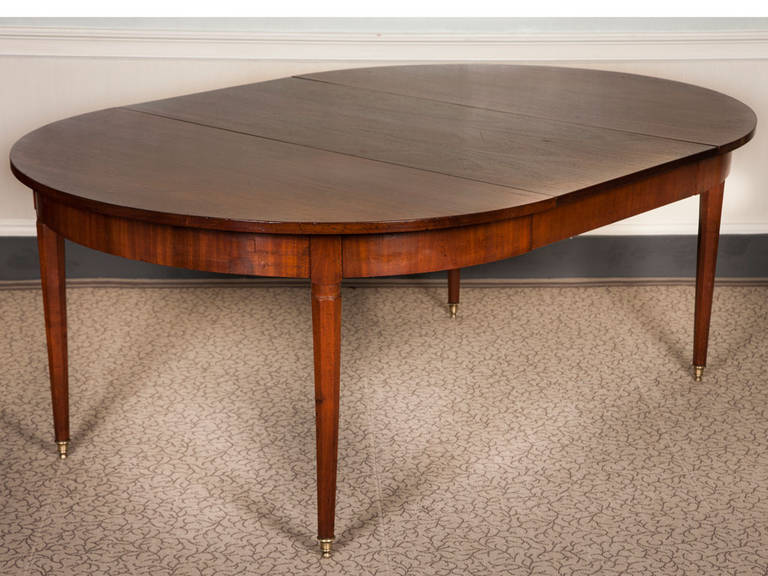 A 19th century walnut extending dining table on finely cast brass castors.