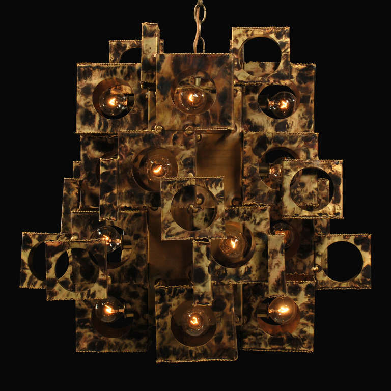 Here is another spectacular Brutalist Chandelier by designer Tom Greene. This is one of the more rare forms with its unique cubist style. He used various sizes of torch cut boxes, which are layered and stair-stepped to create this dramatic