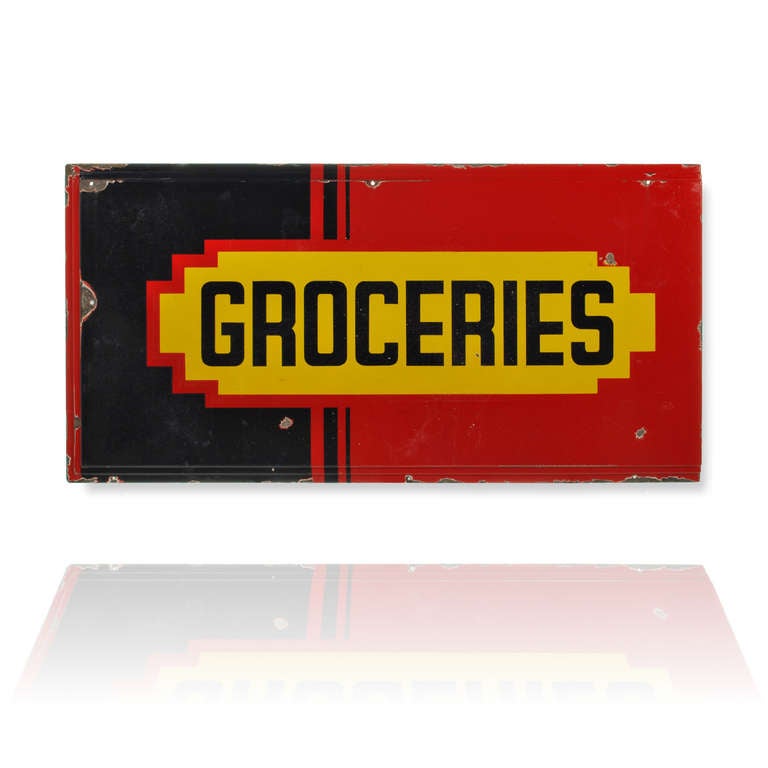 This is a bright and colorful Art Deco era Grocery sign is porcelain over steel. The edge of the sign has a stepped frame border on the edges, adding to the great geometric design and layout of this classic Art Deco sign. The red and black porcelain