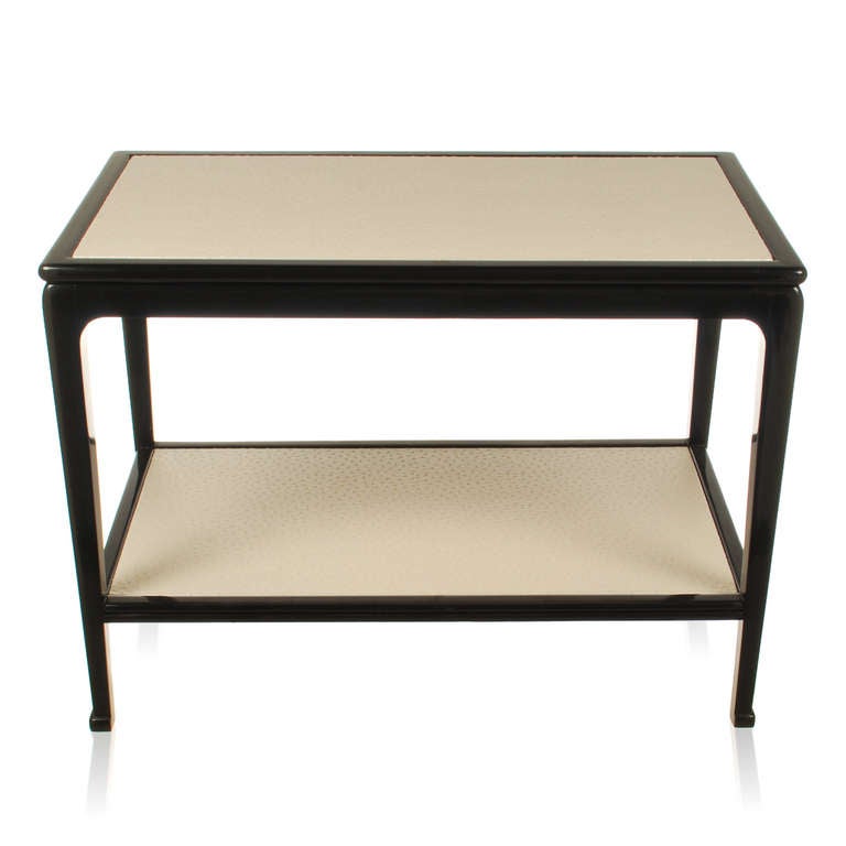 Splendid Italian two tier side table in black lacquer with faux Emu skin inlaid table tops. This stylish table has clean rounded lines you would expect to see on 1940's Italian and French tables. The tapered legs end with a small rounded block foot,