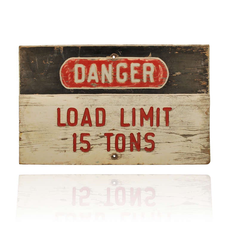 This is a cool old wooden sign indicating Danger maximum load limit 15 tons. This may have been from a bridge or a piece of heavy equipment like a crane.

The letters have been routed into the wood, giving the message a bold look, indicating the