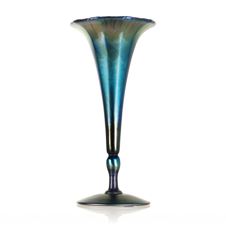 Exquisite Peacock Blue iridescent trumpet vase from Tiffany Studios.  This piece has a soft and exquisitely textured iridescence, which especially adds to the depth of color around the floral form top. It retains its original Tiffany Favrile Glass