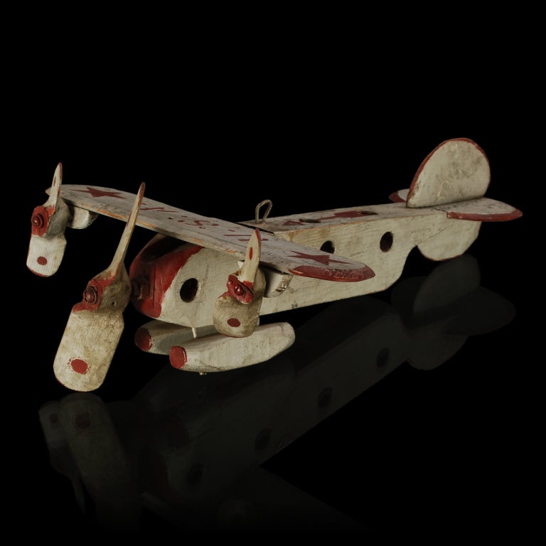 This is a wonderful old Folk Art wooden airplane. It looks similar to the Ford Tri-Motor airplane of the 1920's, with its boxed shape fuselage. The plane is all handmade and has three beautifully carved airplane propellers that really spin. What's