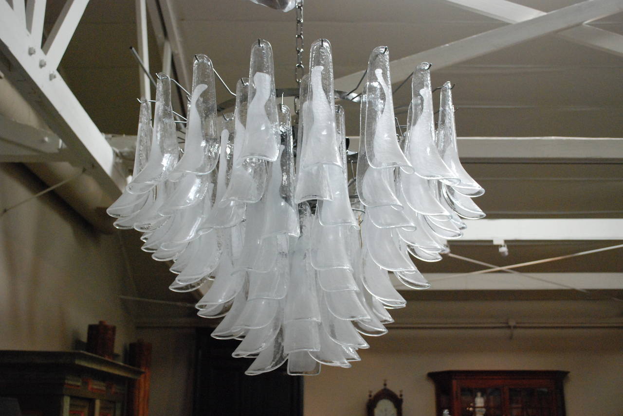 An Italian glass chandelier reminiscent of a mid-20th century chandelier found in Milano, Italy. Features handblown Murano glass. Consisting of eighty leaves surrounding thirteen-light sockets. Top tier with eight, center with four and lower tier