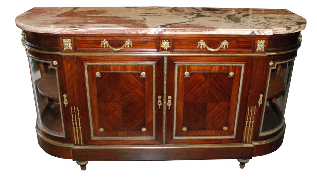 French sideboard with a shaped marble top and rounded corners, stationary center shelf, decorated with ormolu, sitting on turned feet. Sideboard measures 39 1/2h. Back splash measures an additional 14 1/2h.