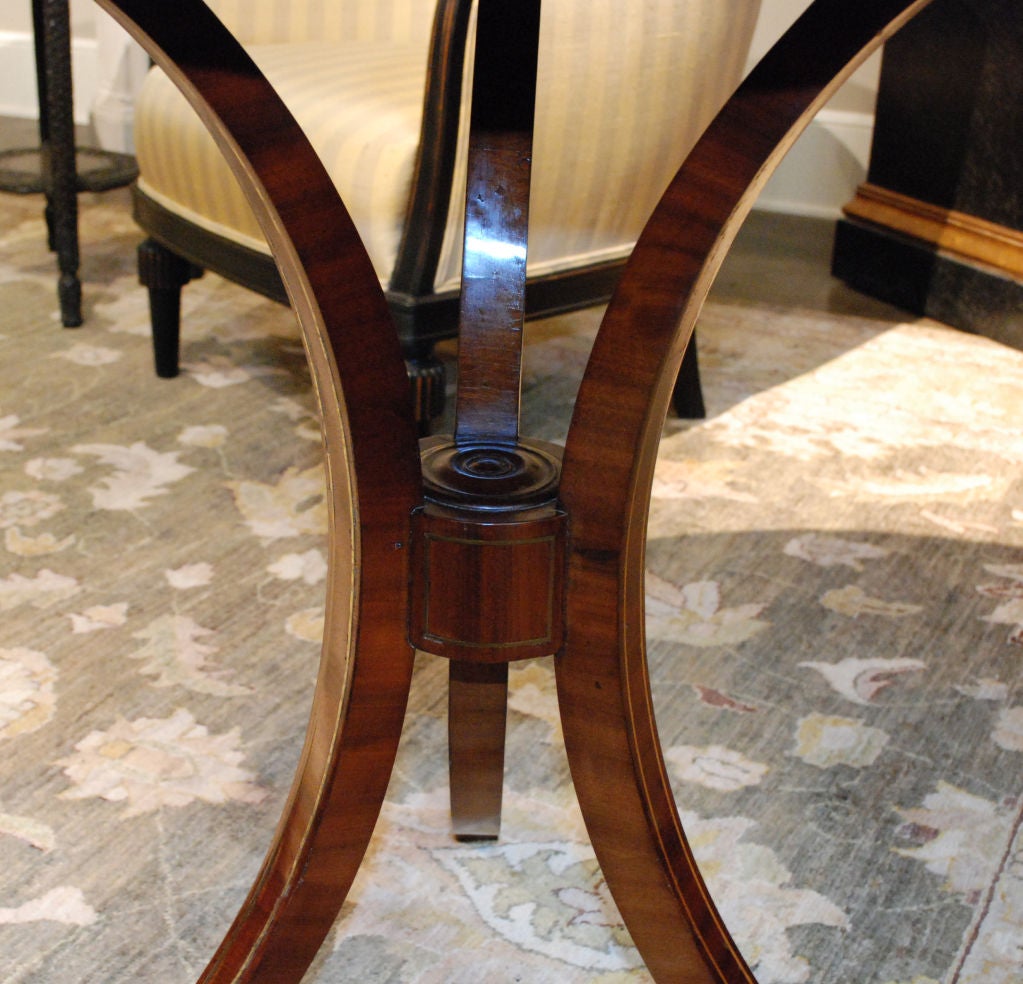Sheraton mahogany pedestal table, a round top above three bowed legs.