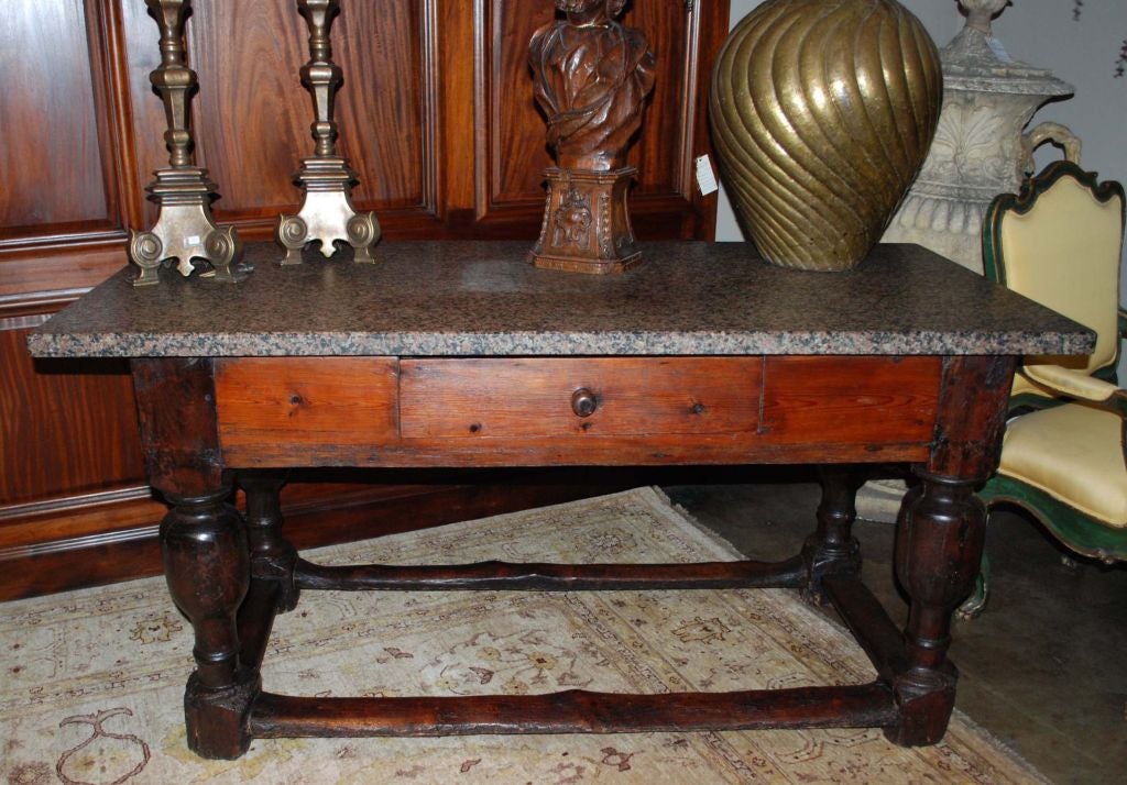 Danish tall preparation table with 1 ½” thick solid stone top, one drawer, sitting on four turned legs between stretchers.