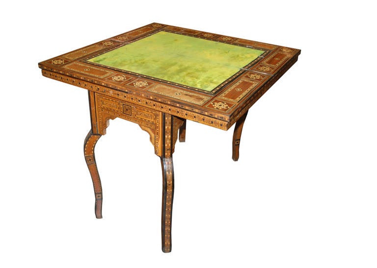 This is an early 20th century exquisite folding Syrian Game Table. It features a folding top which opens as a game board for chess and backgammon. Includes chips and dice.