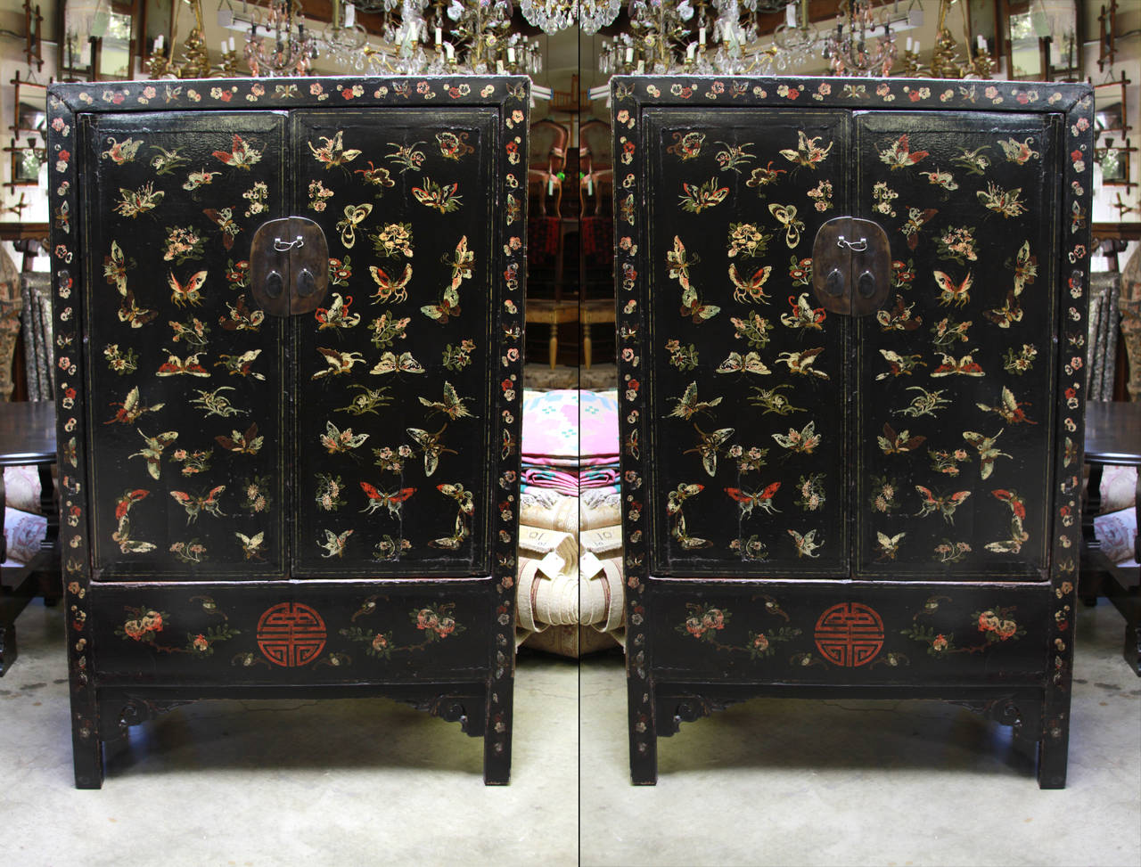 Chinese one of a kind pair of black lacquered tall cabinets. Features butterfly detailing along front, made of elmwood from Shanxi.