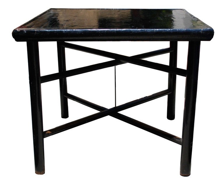 A rare Ming dynasty game table with a crackled black-lacquer finish. Top is removable and legs fold for storage.