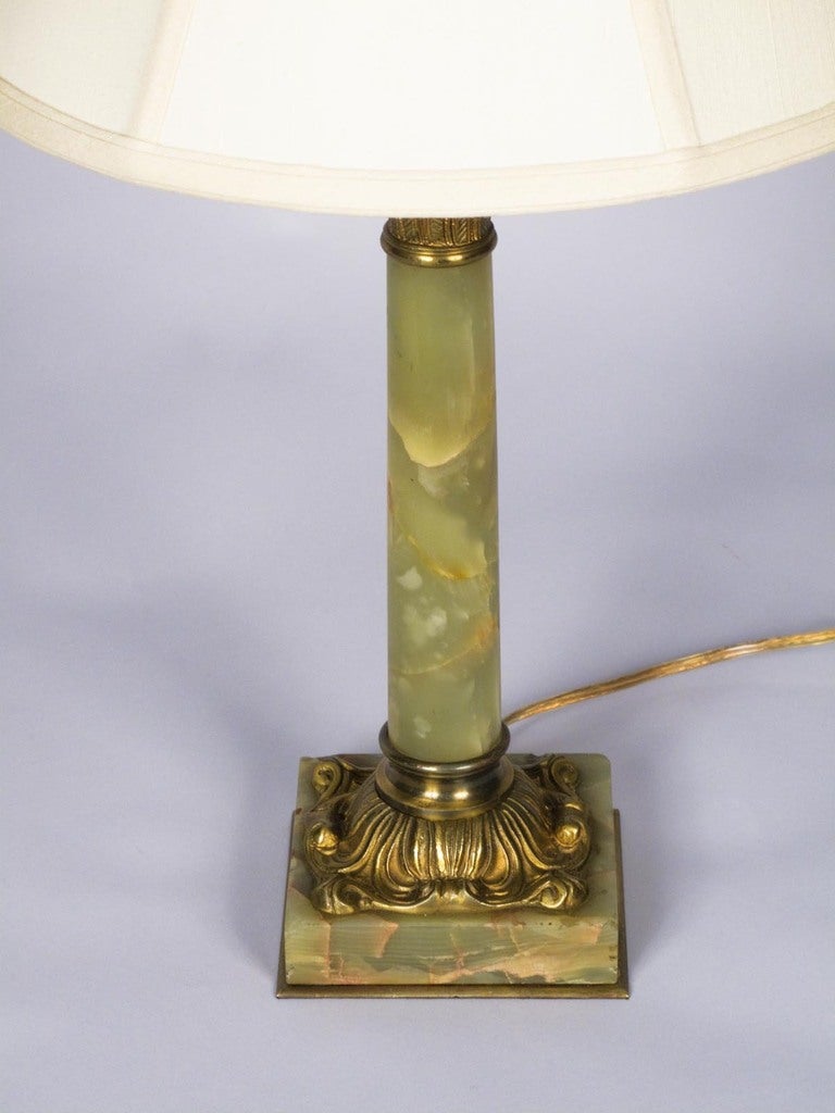An early 1900s table lamp shaped as a Corinthian column and made of green onyx with brass accents. Actual shade is 12