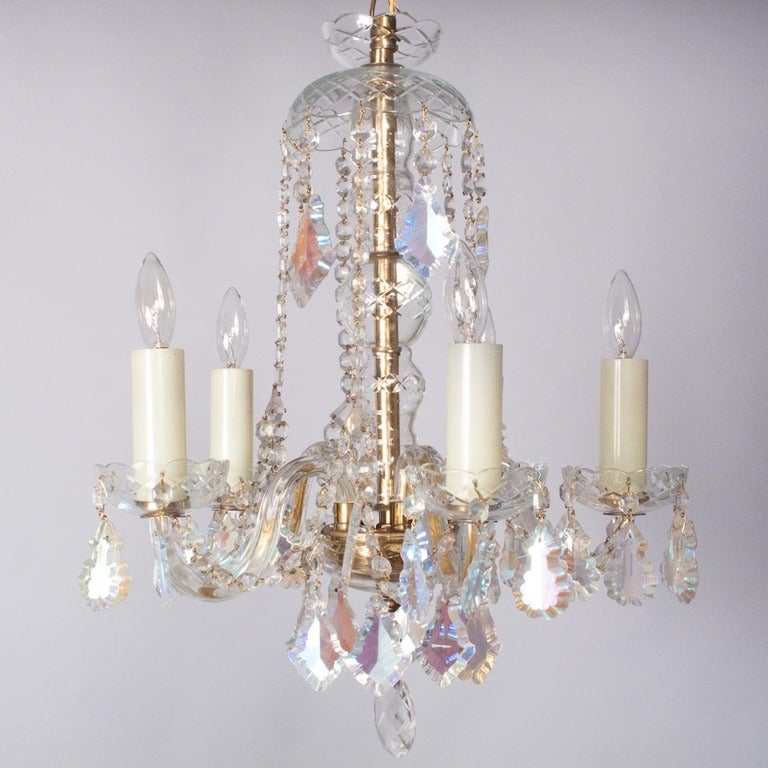 A Pair of Mid-Century Crystal Chandeliers made in the Czech Republic and purchased in France. Each Chandelier has 5 lights with frosted glass candle covers, a brass structure and Bohemian crystals pendants.