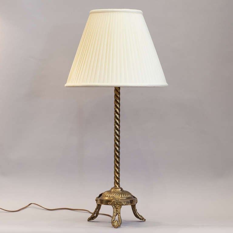 A twisted brass Table Lamp from the early 1900's with a sculpted tripod base with shell motifs. The actual shade is 14