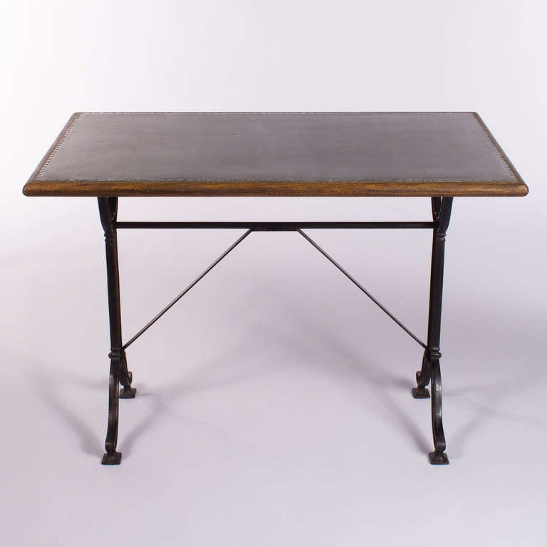 A great classic French Bistro Table with its forged iron base painted in black from the 1920's. Here, the usual marble top has been changed into a sheet of zinc with a trim in Brazilian walnut.