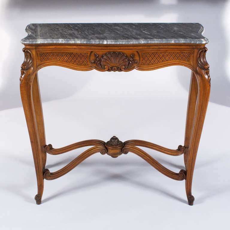 An elegant Console Table in the Louis XV Style made of walnut with a grey double-edged marble top. Featuring cabriolet legs on the walnut base, you will also see lovely acanthus leaf carvings. Hand carvings also include a finial decorated with water