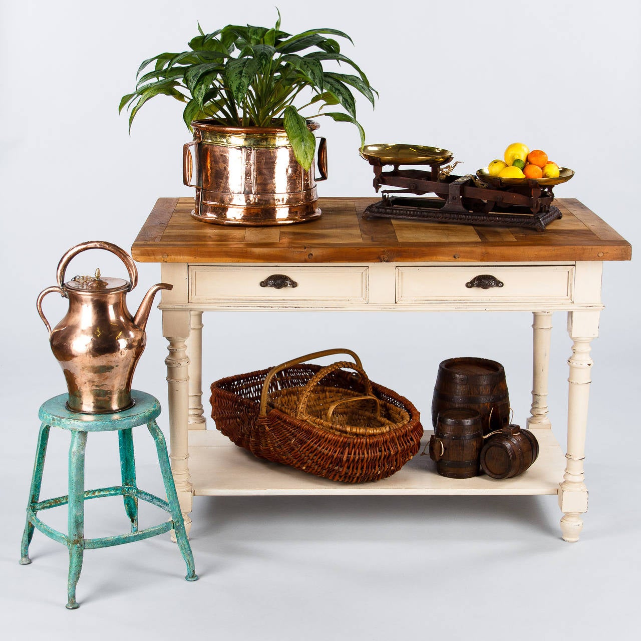 A wonderful working table, perfect for the kitchen and other projects, made of oak painted white. The table, circa 1920s, features two drawers with silver metal pulls, turned legs and a lower shelf. The top, that was added later, is a thick slab of