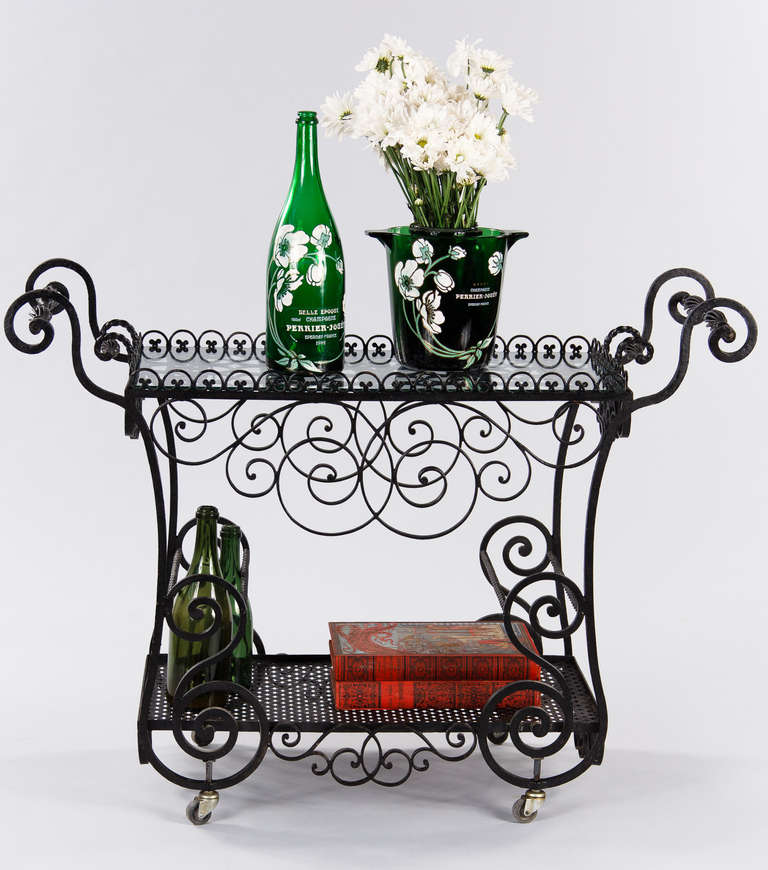 If you like black forged iron and the shape of scrolls, this highly decorative Bar Cart is definitely for you.  The iron work is just magnificent!  The Bar Cart features a removable tray with shaped handles and a clear glass top, storage for 6