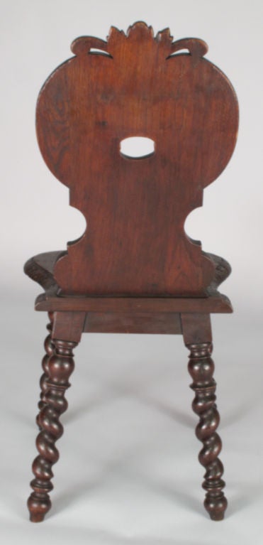 A very decorative 18th century Renaissance Style single Chair made of oak with twisted legs. The carved back has a cartouche top, flower and scroll motifs and a face mask with openwork in place of the mouth.