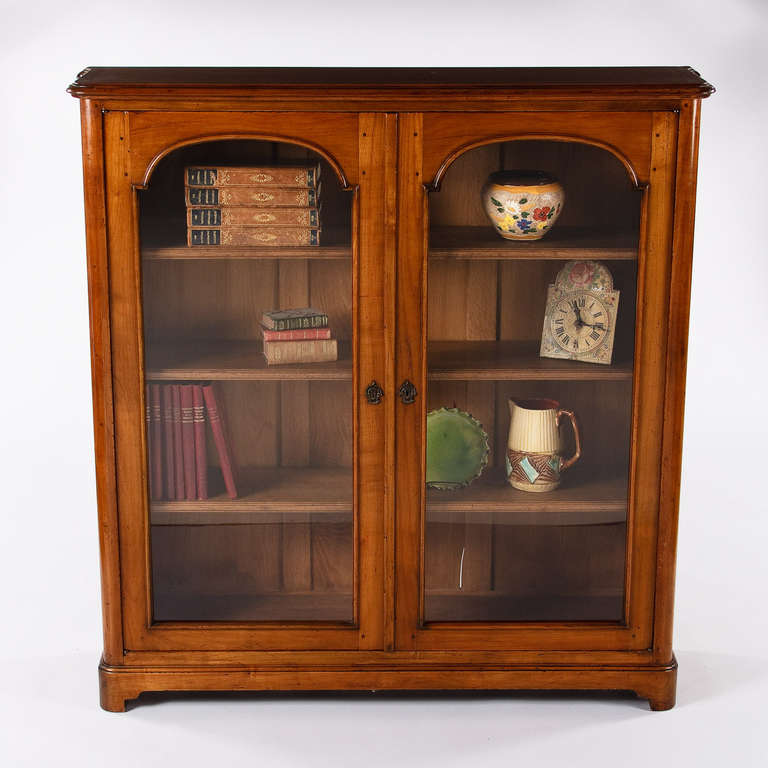 Beautiful lines, great proportions, top quality craftsmanship! A very finely-crafted Louis XIV Style Bookcase made entirely of solid cherry wood. The two-door bookcase features glass doors framed with stunning arches and rests on bracket feet. This
