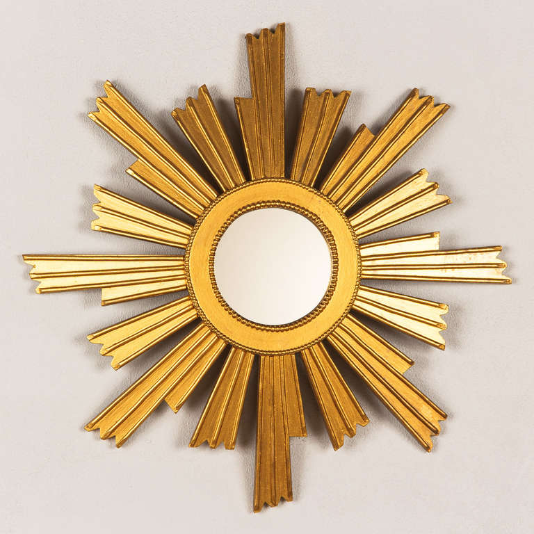 A mid-century giltwood sunburst mirror, French circa 1950. At the center is a 4.75