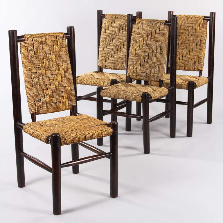 Four chairs that are reminiscent of the creations of French Designer Charlotte Pierrand in the 1950s. Made in simple, almost primitive style with frames with  thick rounded legs in ebonized and varnished wood and thick rush seats with interlaced