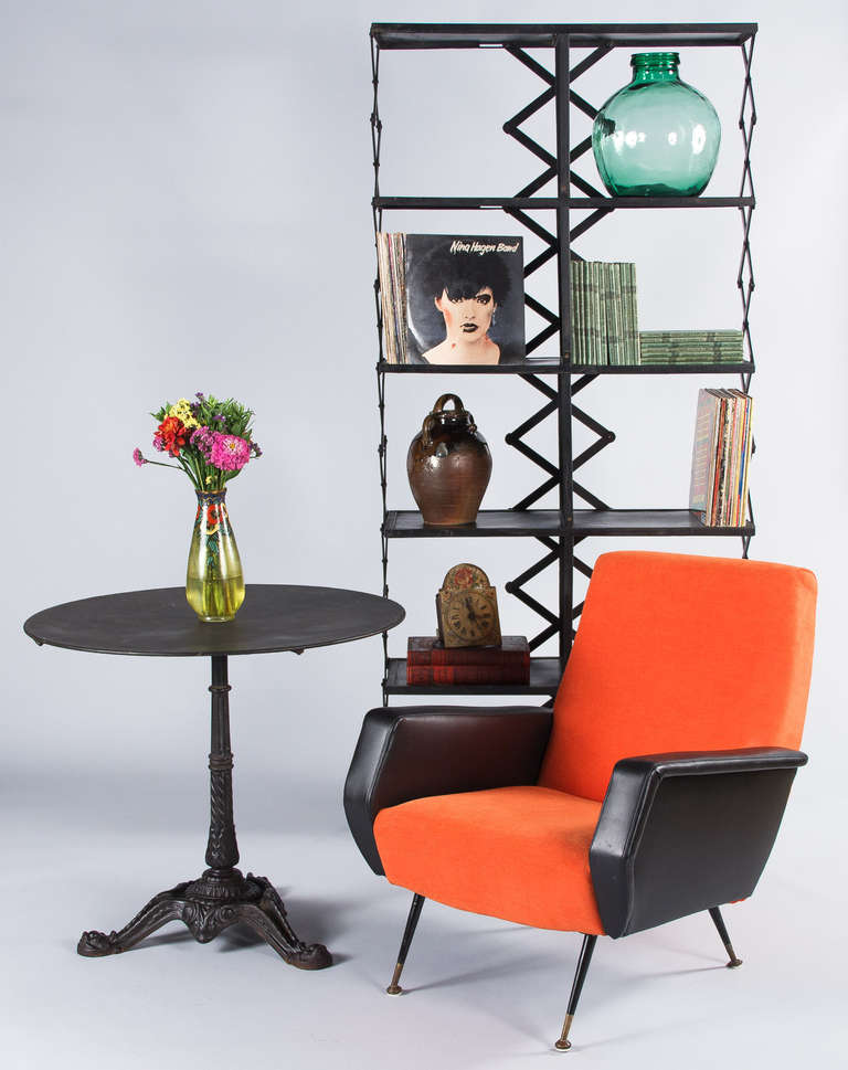A French vintage shelving unit from the 1970s that was custom-made for the Chevignon men clothing store in the city of Lyon. This very original piece is made of iron painted black and the top of each shelf is tole. The open sides and back feature a