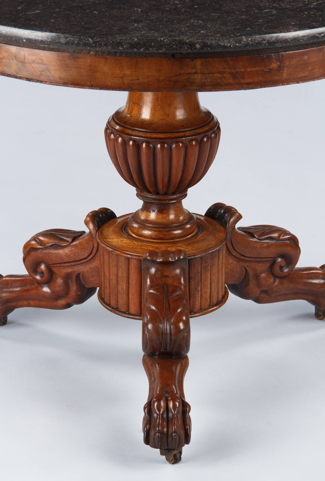 A wonderful pedestal table or gueridon from the Napoleon III period, circa 1870s. Found in a private home in the Loire Region, this center table is topped with a round black marble top. The walnut wood tripod base features a gadrooning bulb in its