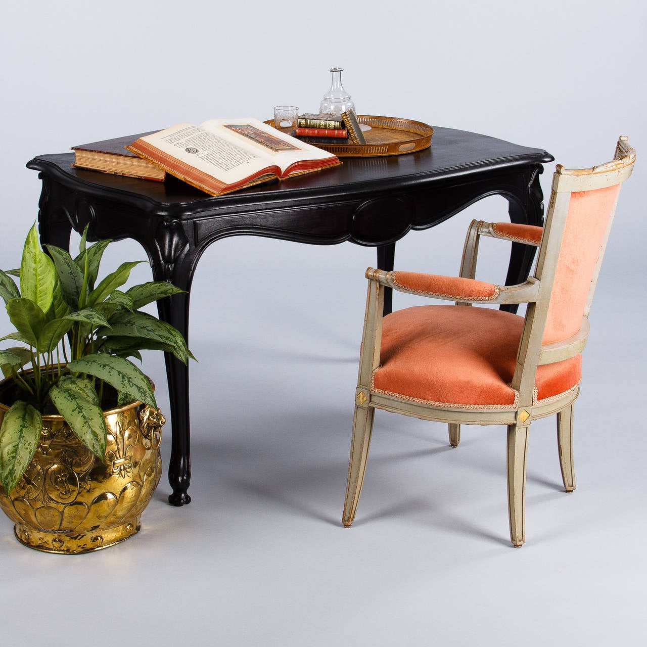 A Napoleon III period table in ebonized pearwood with curved and scrolled legs and a scalloped apron with a medallion in its center. The table features a single drawer on one side. Great center table or side table that can also works as a desk. From