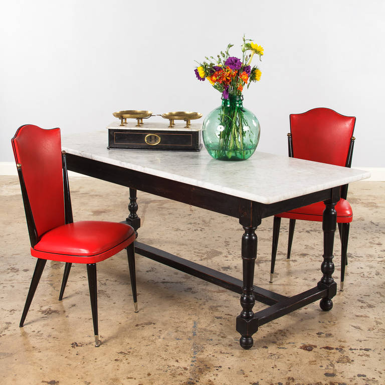 Black and white. A magnificent table with a white marble top and an ebonized beachwood base with turned legs and an H-shaped stretcher. That table was originally a working table used in a Provençal pastry shop or a chocolaterie to roll dough and