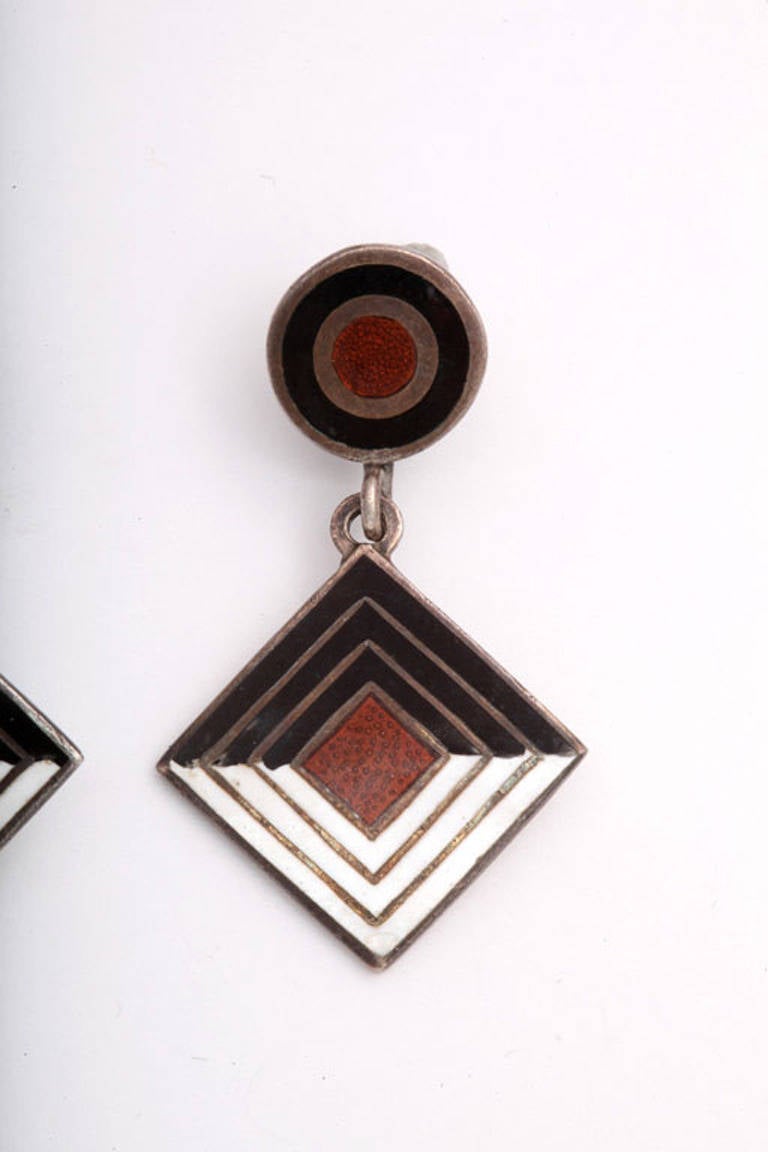 Clean geometric whimsy in a complex, beautifully enamelled pair of silver earrings. This is a unique design by Margot, one of the master jewelers during the silver jewelry renaissance in Mexico. The shadow visible on the left earring was adhesive