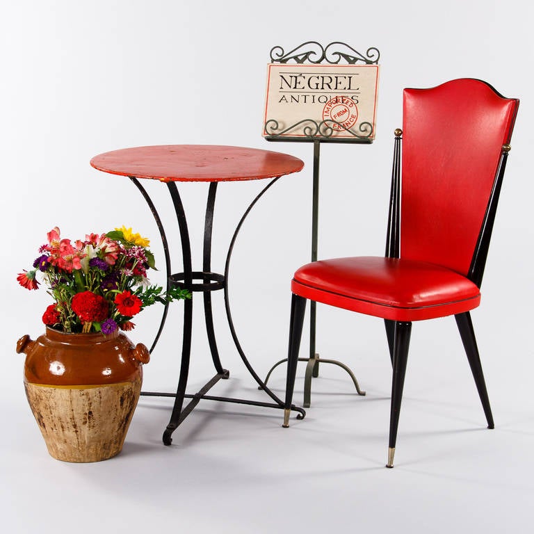 A charming iron pedestal table from the 1920s found in the Provence region. The gueridon had been painted in black with a bright red top. The base has curved legs and an X-shaped stretcher. A colorful piece to fit on your patio, screened porch or
