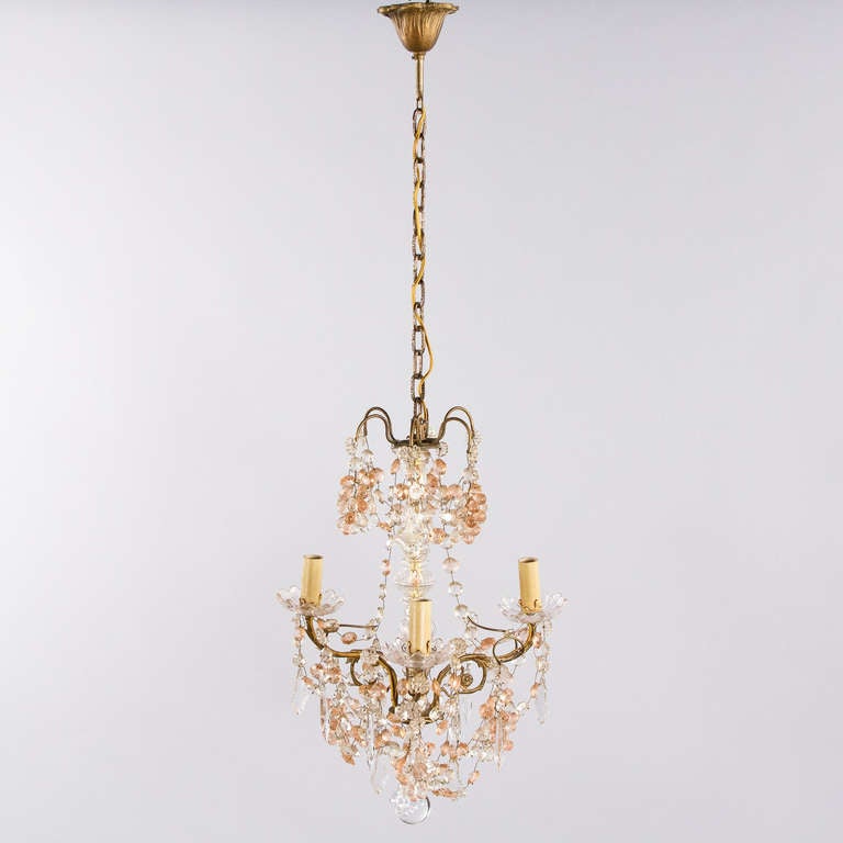 A charming three-light brass French chandelier from the 1930's with pink glass grapes and clear crystal beads and drops. The chandelier measures 41
