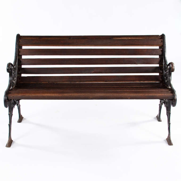 A wonderful Park Bench made with slats of oak and carved forged iron sides.