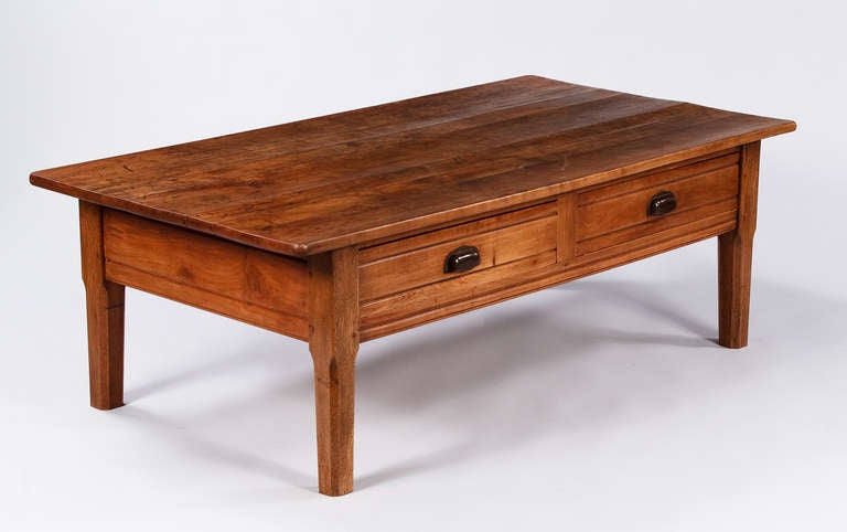 A fabulous 1920's French Country Farm Table in solid walnut that was converted into a coffee table. The table features two drawers with round metal pulls. Although the table is walnut, the legs are oak.