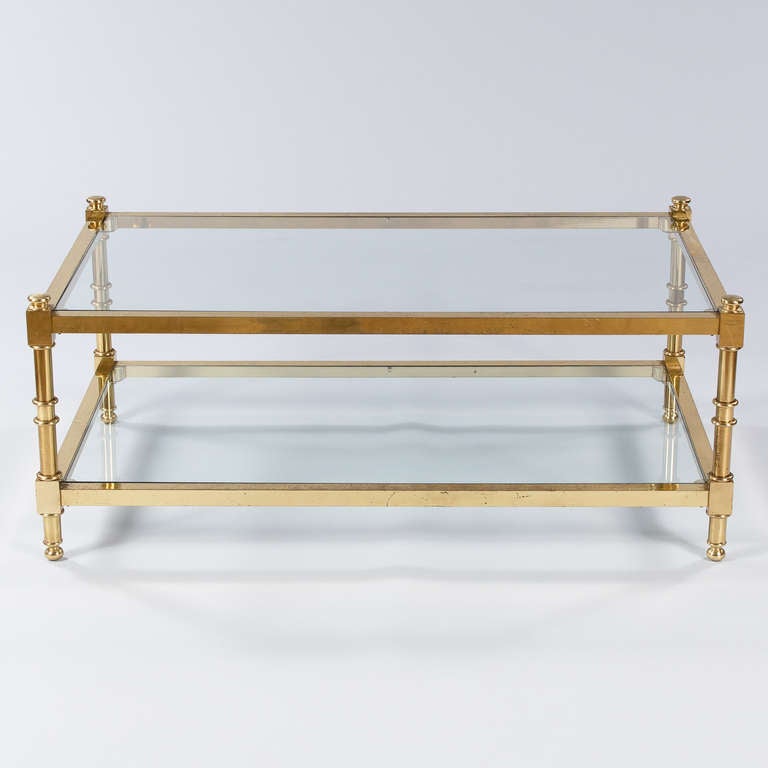 A fabulous large French Mid Century Coffee Table made of brass with two smoked glass shelves.  A bold and classy statement for any decor in your home!