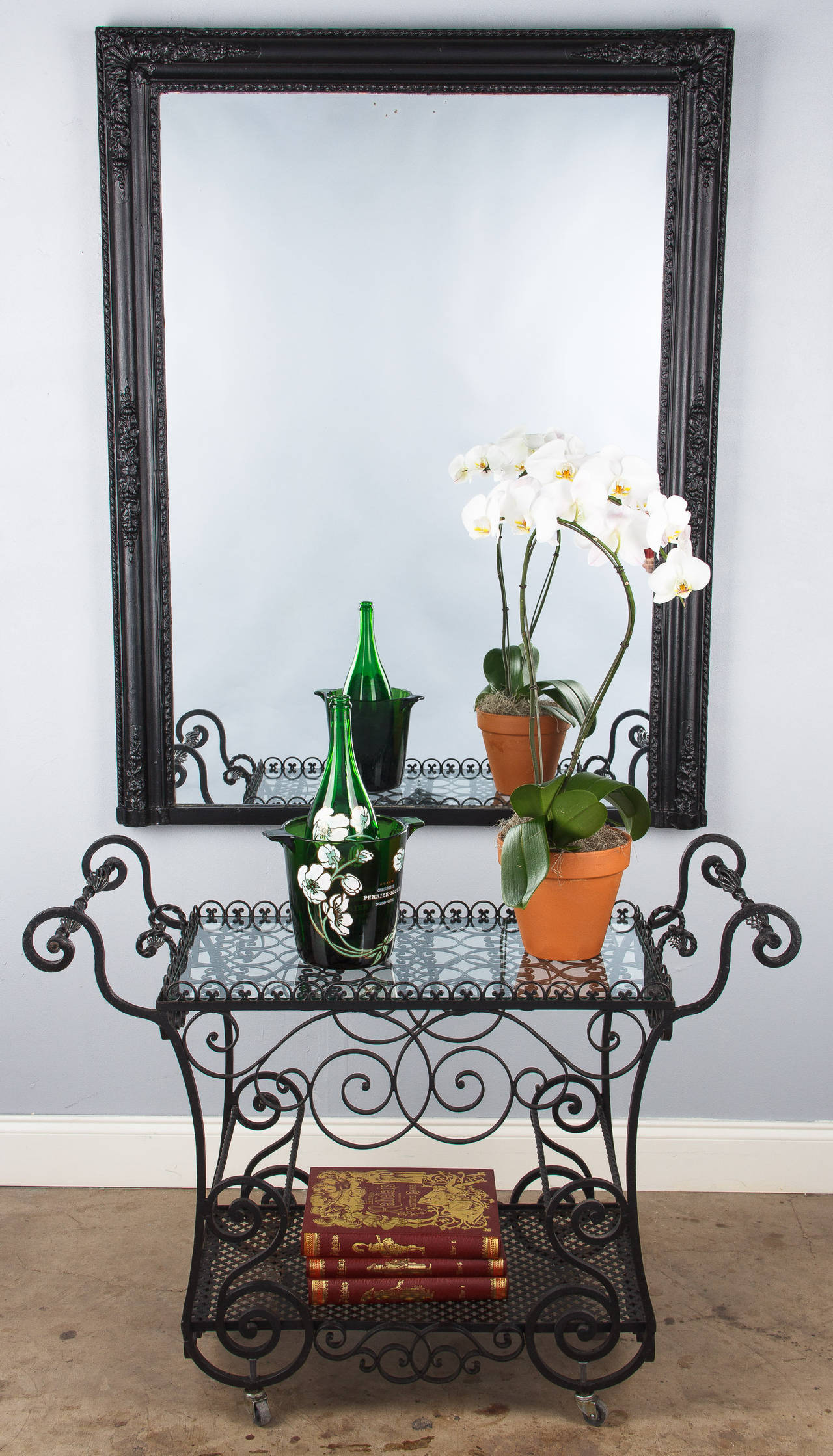 A Napoleon III Period mirror from the Provence region of France painted black with flower and foliage moldings on its frame with a rope motif trimming the edge.