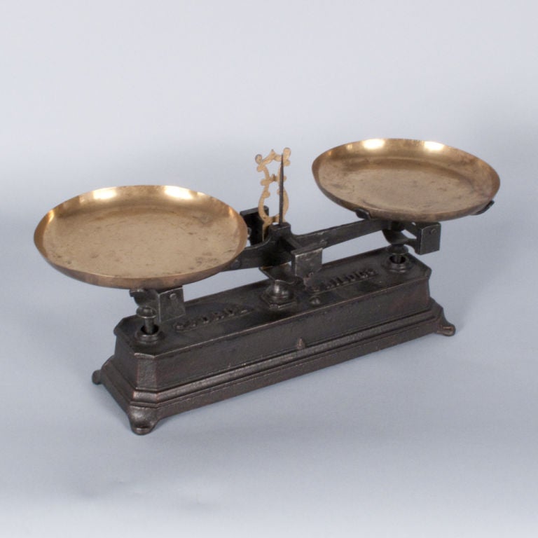 A decorative French Balance Scale made of cast iron painted black with brass plateaux. Beautiful patina on metal.