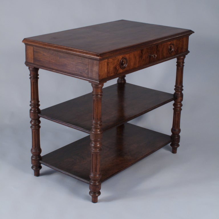 An early 1900's Henri II Style Desserte Buffet made of walnut with turned legs.  The desserte has two shelves and one drawer with wooden knobs. Great serving table, console table, or display piece!