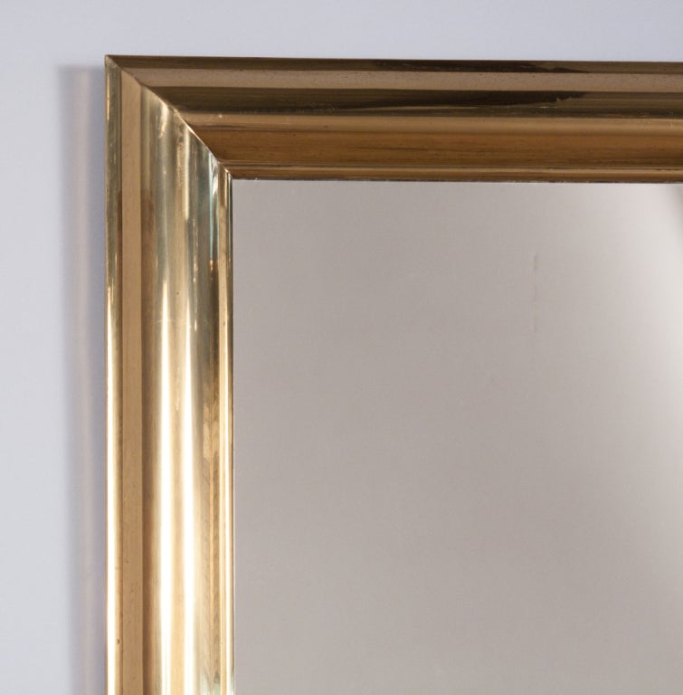 A simple and elegant modern French Mirror from the 1970s with a polished brass frame. Mirror can be hung vertically or horizontally. It is in excellent condition with some minor age appropriate discoloration on brass.