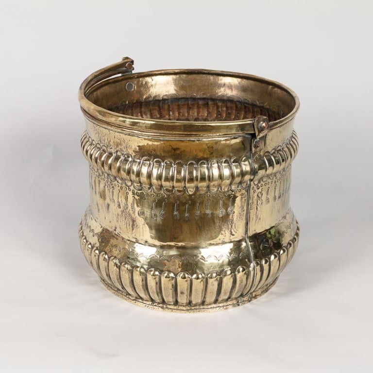 A decorative French jardiniere made of hammered and embossed brass from the Bresse Region. Two wide bands of repousse gadrooning make the piece instantly striking, one around the bulged base, the other near the top. The belly between the gadrooned