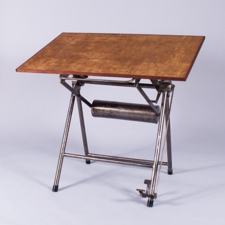A French Mid-Century Architect's Drafting Table with a polished cast iron base and a beech wood top with a mahogany trim.  The height of the Desk is adjustable to multiple positions with a weight and a brake pedal. Table was designed by Heliolithe,