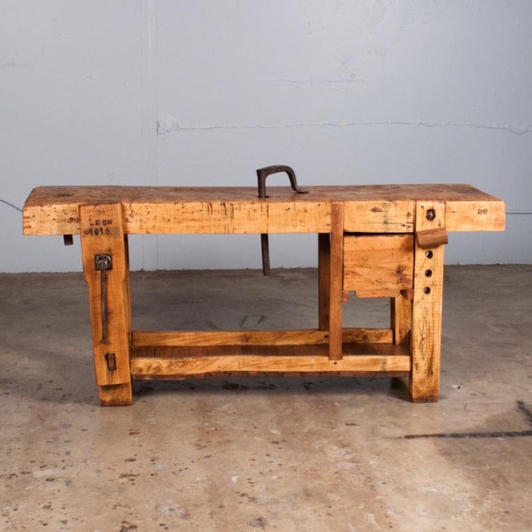 This rustic Carpenter's Workbench from Southern France is made of elm wood with a pine bottom shelf.  The Etabli has a drawer and its original vise. It is signed Leon and dated 1910.