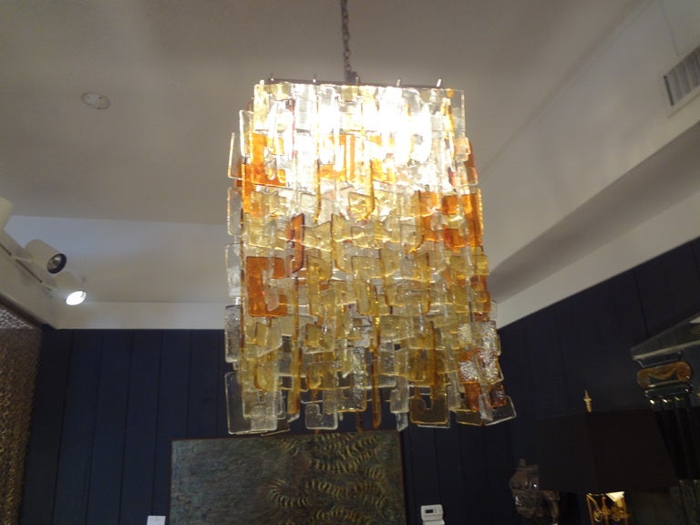 Monumental Italian Mid-Century Modern multicolored interlocking murano glass chandelier on chrome base by Carlo Nason for Mazzega.
This stunning murano chandelier is comprised of clear, gold and yellow glass and has been newly wired for U.S.