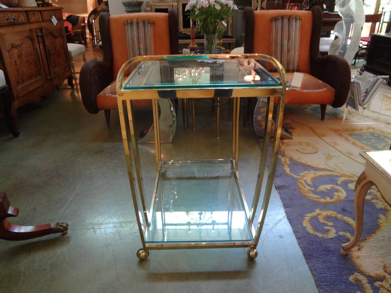 Sleek Hollywood Regency seamless brass drinks or serving cart with beveled glass shelves.

Please click KIRBY ANTIQUES logo below to view additional pieces from our vast inventory.
 