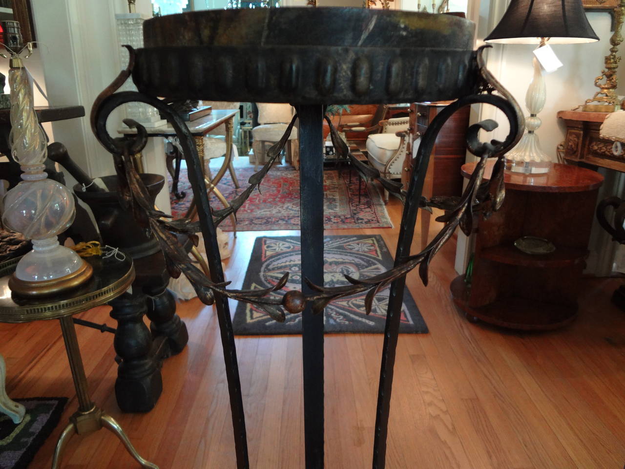 Well-made Italian hand-forged iron and gilt iron pedestal table with faux marble wood top.