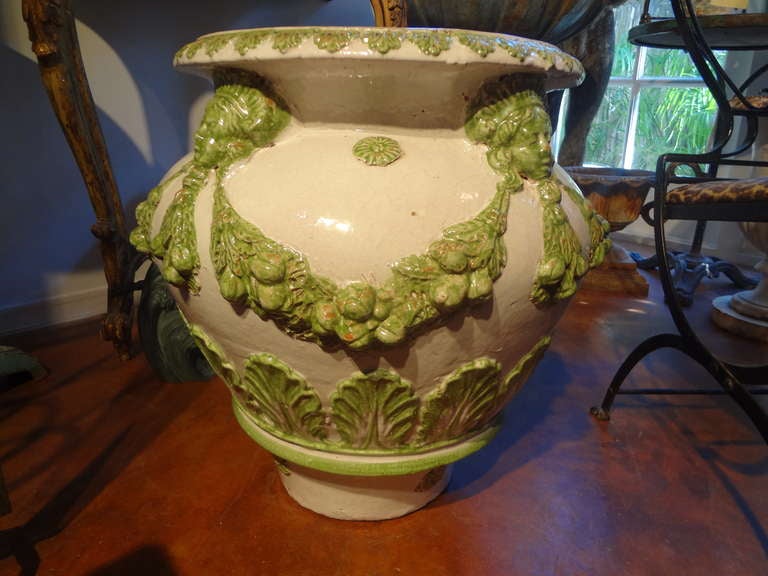 Large Italian neoclassical style Glazed Terracotta Urn.
Classic Italian glazed neoclassical style terra-cotta planter, jardinière or urn (22 inches H) decorated with masks and garlands. This beautiful French urn can be used indoors or