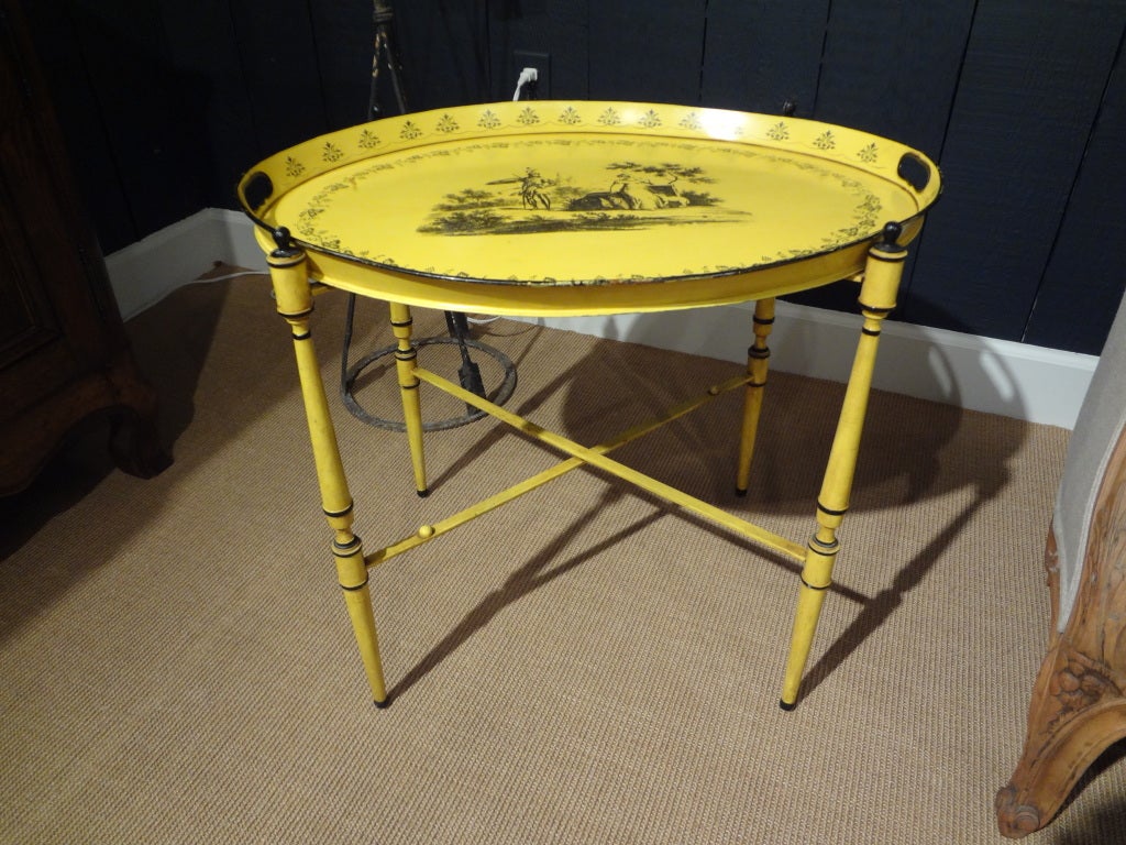 Charming Italian tole tray on stand in a great yellow color with a Neoclassical design from the 1940's. This versatile
table would well as a cocktail table, side table, or end table