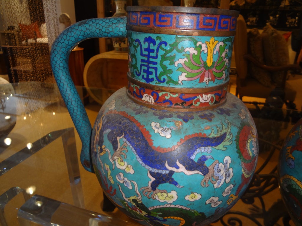 UNUSUAL PAIR OF CHINESE CLOISONNE PITCHERS WITH DRAGONS,SWAN HANDLES AND GREEK KEY DESIGN.
